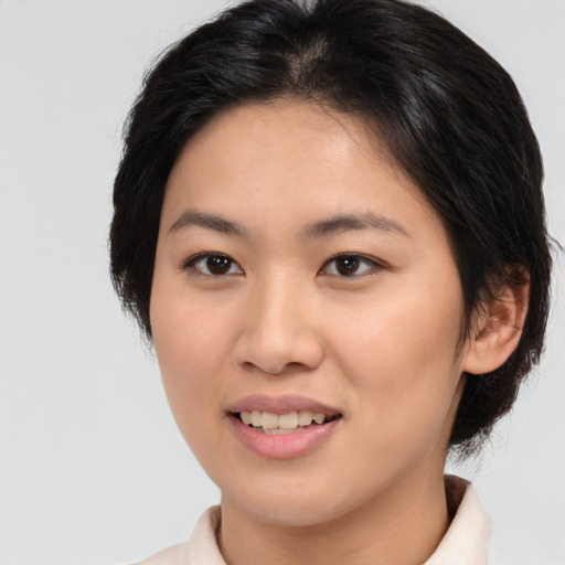 Joyful asian young-adult female with medium  brown hair and brown eyes