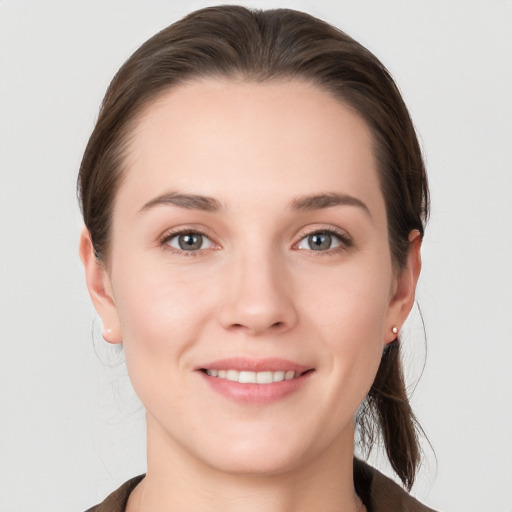 Joyful white young-adult female with medium  brown hair and grey eyes