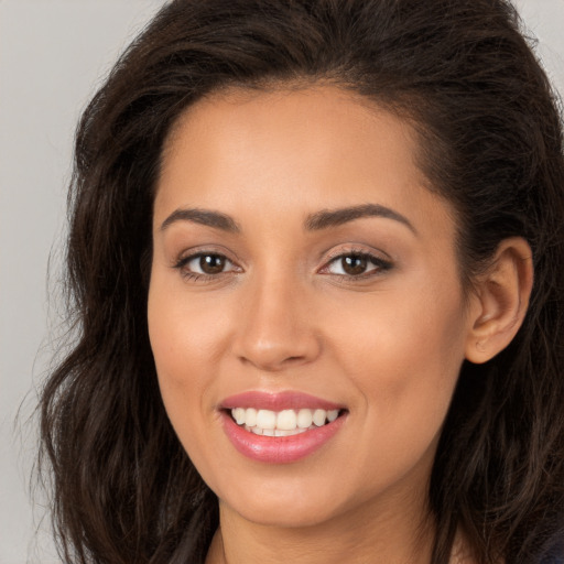 Joyful white young-adult female with long  brown hair and brown eyes