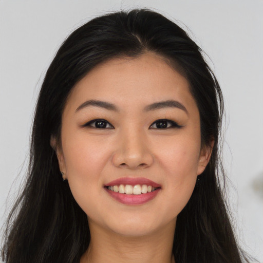 Joyful asian young-adult female with long  brown hair and brown eyes