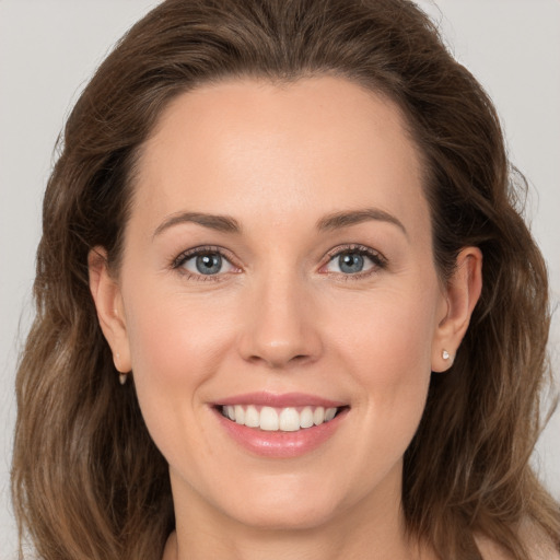 Joyful white young-adult female with long  brown hair and grey eyes