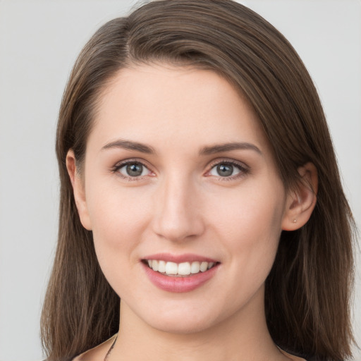 Joyful white young-adult female with long  brown hair and grey eyes