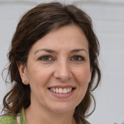 Joyful white adult female with medium  brown hair and grey eyes