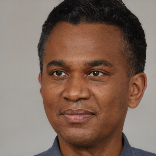 Joyful black adult male with short  black hair and brown eyes