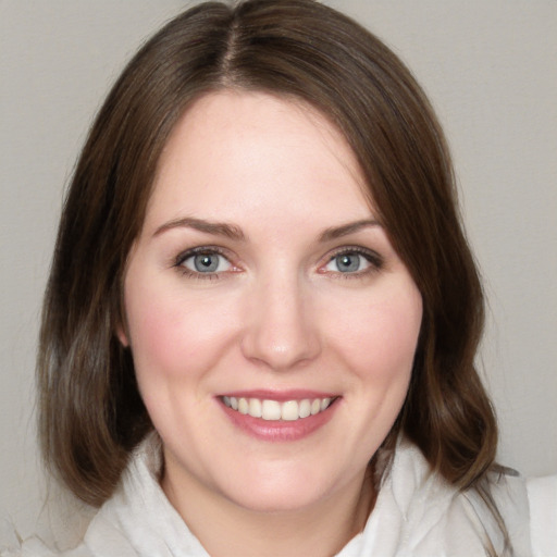 Joyful white young-adult female with medium  brown hair and green eyes