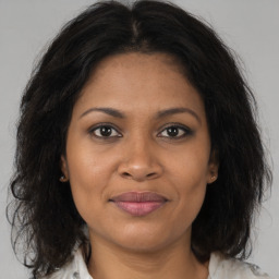 Joyful black adult female with medium  brown hair and brown eyes