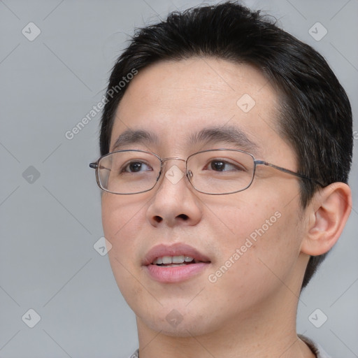 Joyful asian young-adult male with short  brown hair and brown eyes