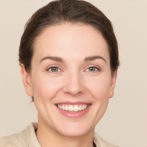 Joyful white young-adult female with short  brown hair and grey eyes