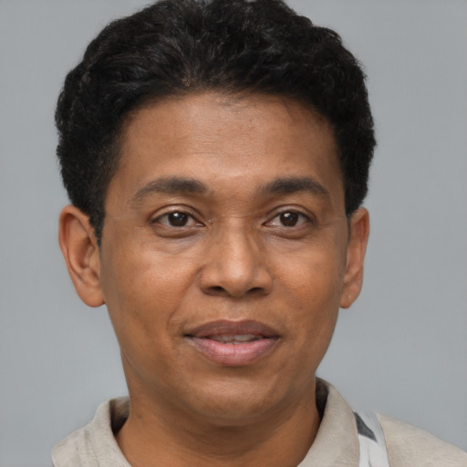 Joyful black adult male with short  black hair and brown eyes