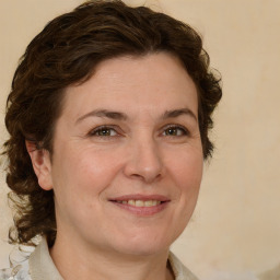 Joyful white adult female with medium  brown hair and green eyes