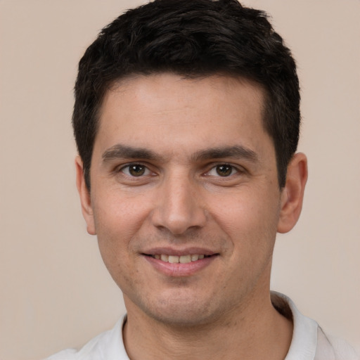 Joyful white young-adult male with short  black hair and brown eyes