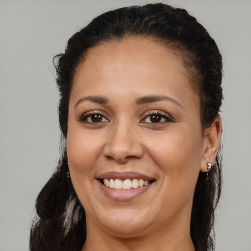 Joyful latino adult female with long  brown hair and brown eyes