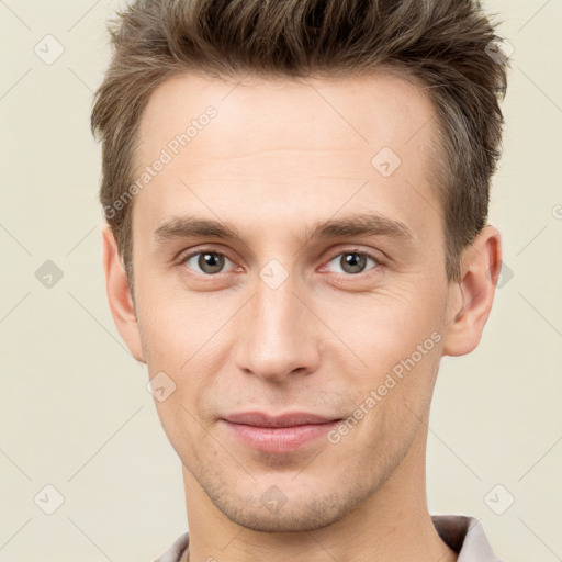 Joyful white young-adult male with short  brown hair and grey eyes