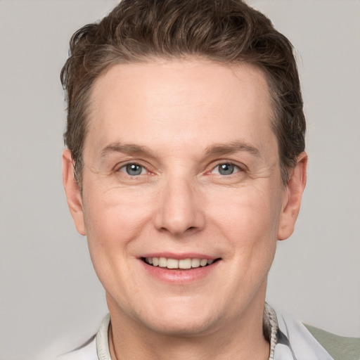 Joyful white adult male with short  brown hair and grey eyes