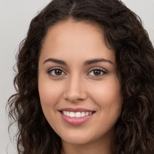 Joyful white young-adult female with long  brown hair and brown eyes