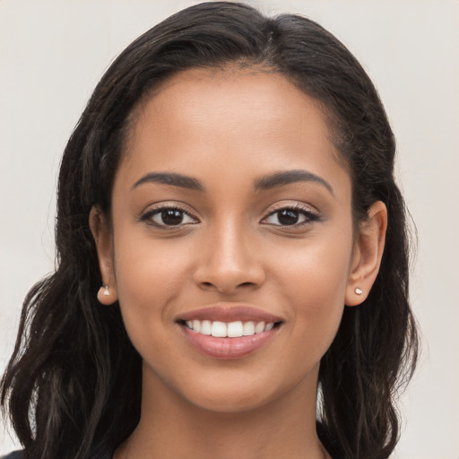 Joyful latino young-adult female with long  brown hair and brown eyes