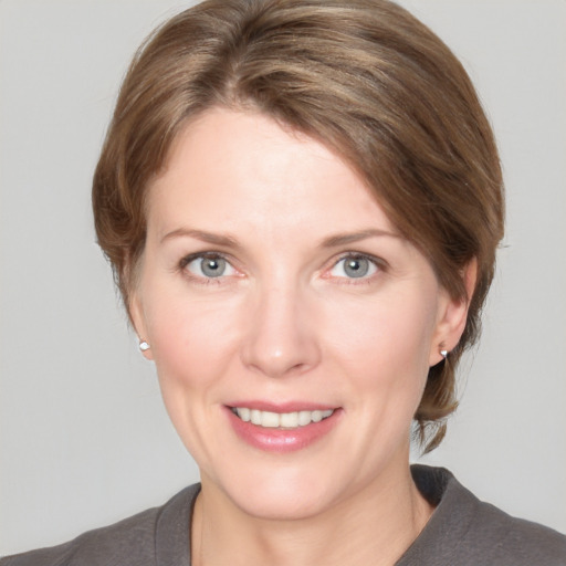 Joyful white adult female with medium  brown hair and grey eyes