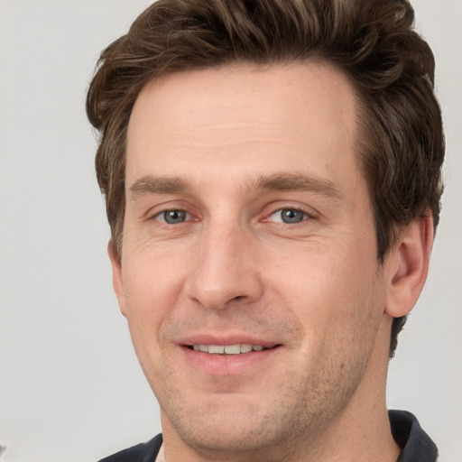 Joyful white adult male with short  brown hair and grey eyes