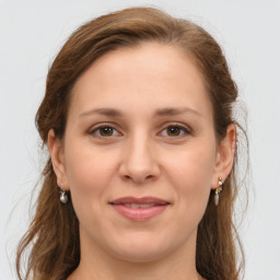 Joyful white young-adult female with long  brown hair and green eyes