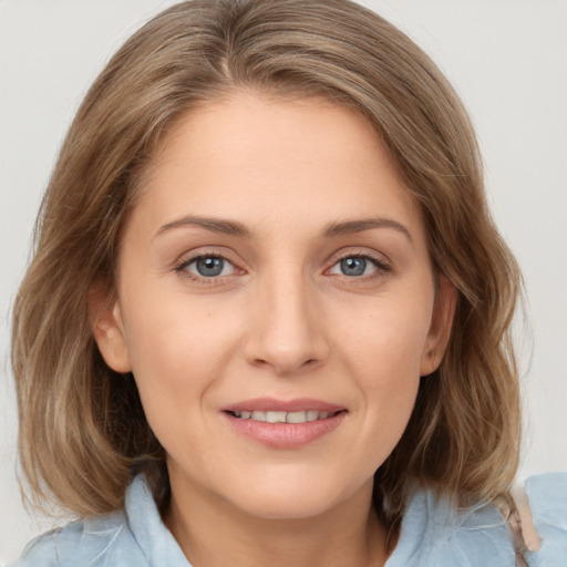 Joyful white young-adult female with medium  brown hair and grey eyes