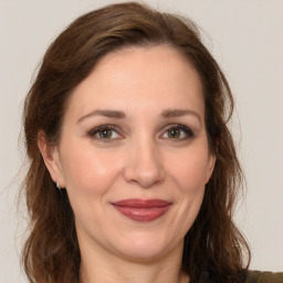 Joyful white adult female with long  brown hair and brown eyes