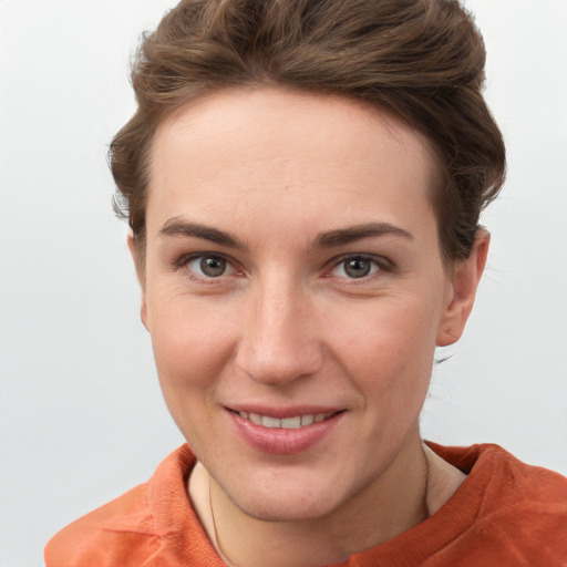 Joyful white young-adult female with short  brown hair and grey eyes