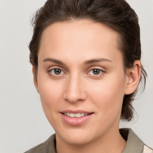 Joyful white young-adult female with short  brown hair and grey eyes