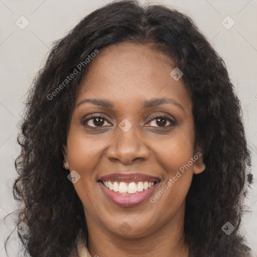 Joyful black young-adult female with long  brown hair and brown eyes