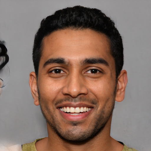 Joyful latino young-adult male with short  black hair and brown eyes