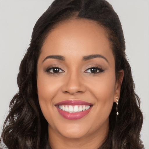 Joyful latino young-adult female with long  brown hair and brown eyes