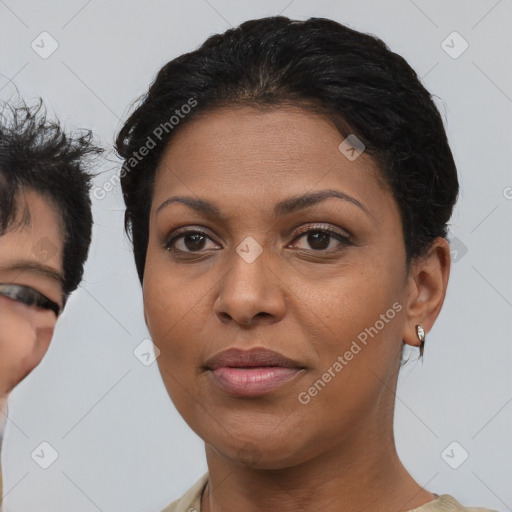 Joyful black young-adult female with short  brown hair and brown eyes