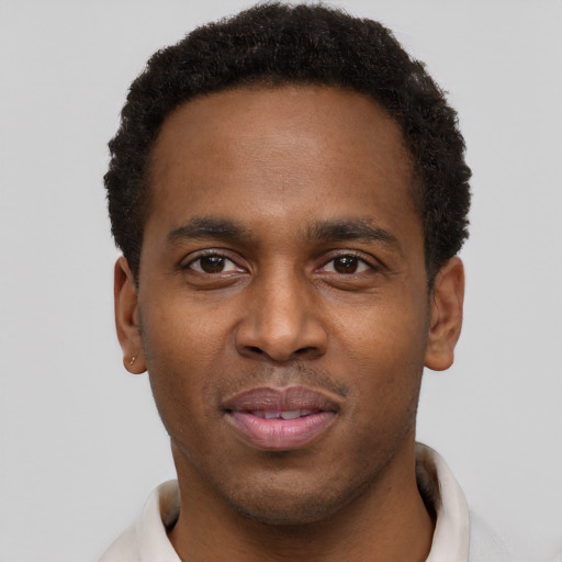 Joyful black young-adult male with short  brown hair and brown eyes