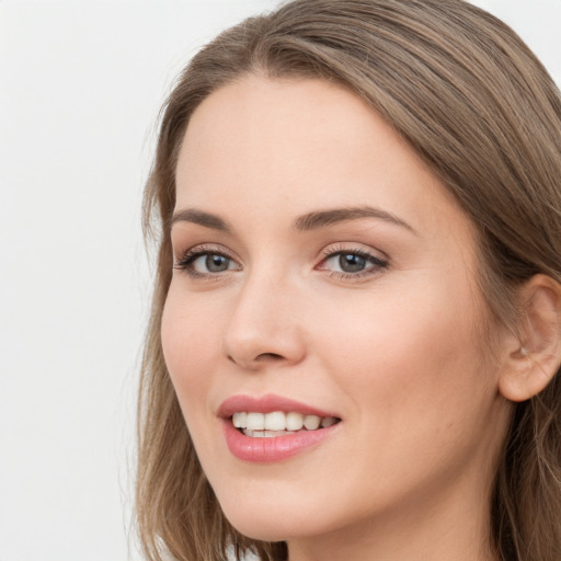 Joyful white young-adult female with long  brown hair and blue eyes