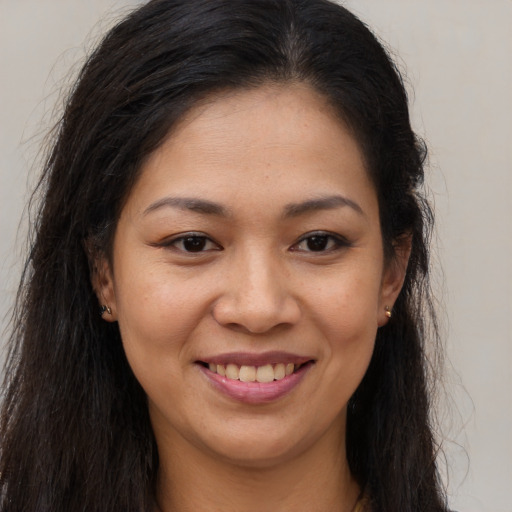 Joyful latino young-adult female with long  brown hair and brown eyes