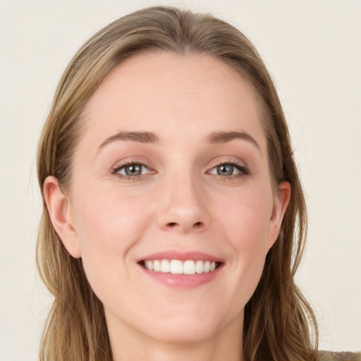 Joyful white young-adult female with long  brown hair and blue eyes