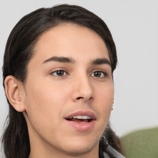 Joyful white young-adult male with long  brown hair and brown eyes