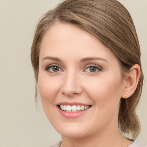 Joyful white young-adult female with medium  brown hair and blue eyes