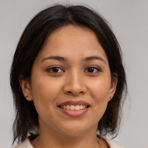 Joyful latino young-adult female with medium  brown hair and brown eyes