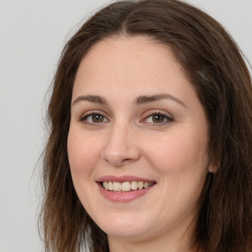 Joyful white young-adult female with long  brown hair and brown eyes