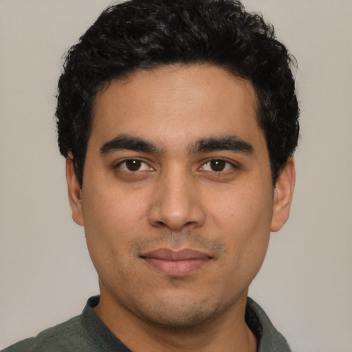 Joyful latino young-adult male with short  black hair and brown eyes