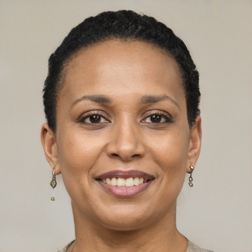 Joyful black adult female with short  brown hair and brown eyes