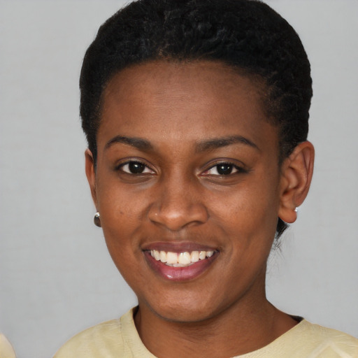 Joyful black young-adult female with short  brown hair and brown eyes