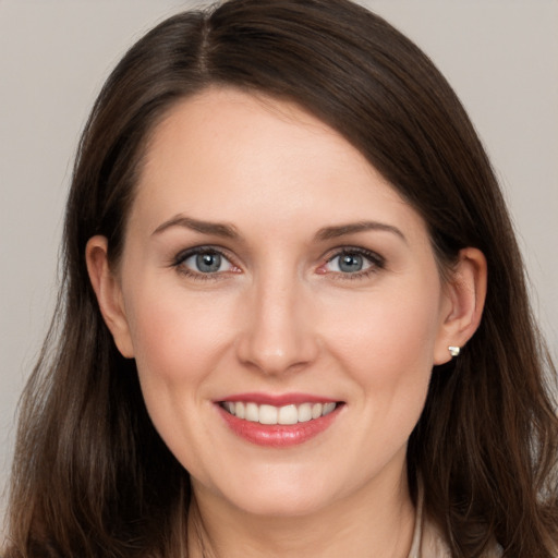 Joyful white young-adult female with long  brown hair and grey eyes