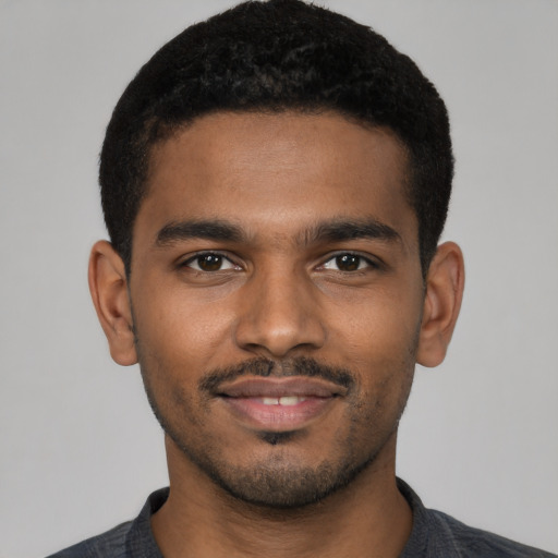 Joyful black young-adult male with short  black hair and brown eyes