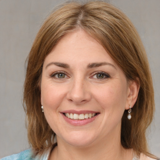 Joyful white young-adult female with medium  brown hair and green eyes