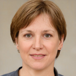 Joyful white adult female with medium  brown hair and grey eyes