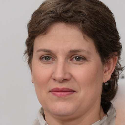 Joyful white adult female with medium  brown hair and grey eyes