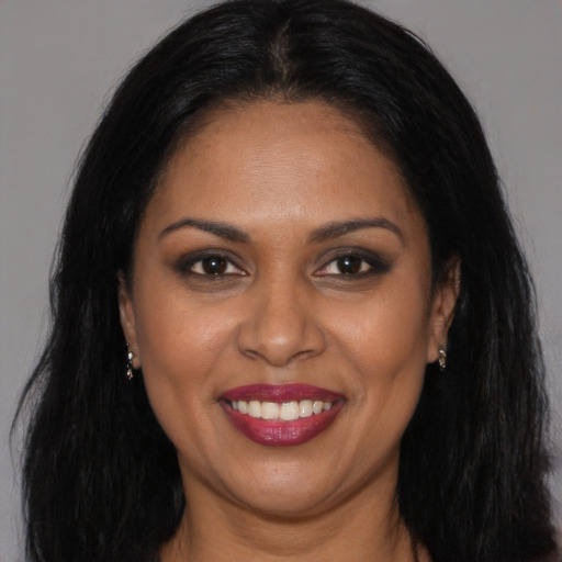 Joyful black young-adult female with long  brown hair and brown eyes