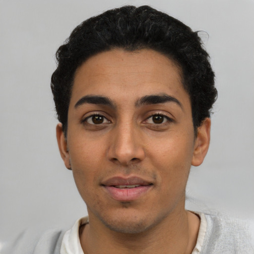 Joyful latino young-adult male with short  black hair and brown eyes