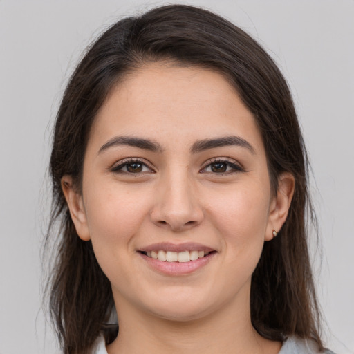 Joyful white young-adult female with long  brown hair and brown eyes